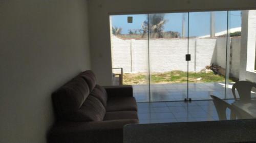 a living room with a couch and a view of a beach at DUPLEX BEIRA MAR TABATINGA in Nísia Floresta