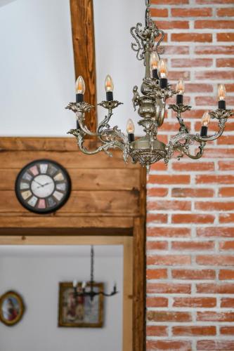 a chandelier with a clock next to a brick wall at Apartmani Lunija in Gornji Milanovac