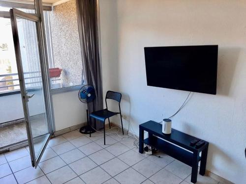 a room with a tv on a wall with a chair and a table at Apartment with balcony near D sseldorf in Neuss