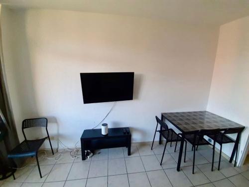 a room with a table and a television on a wall at Apartment with balcony near D sseldorf in Neuss