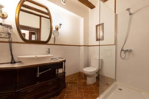 a bathroom with a sink and a toilet and a mirror at Casona Indiana de Ayuelas in Ayuelas