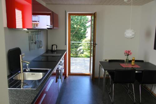 a kitchen with a sink and a table with chairs at Ferienwohnung Blütenweg Kluftern in Friedrichshafen