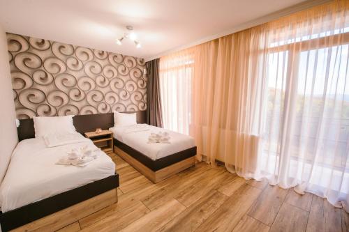 a bedroom with two beds and a window at Пиргуля in Miladinowzi
