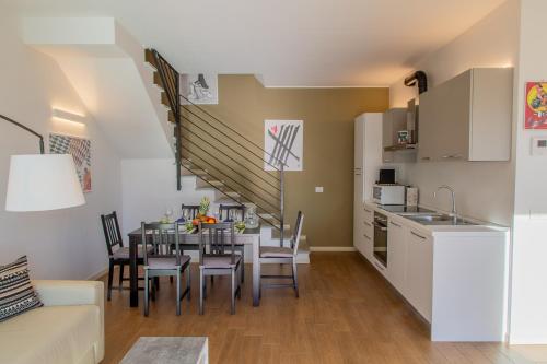 a kitchen and a dining room with a table and chairs at Maison Vespa in Argegno
