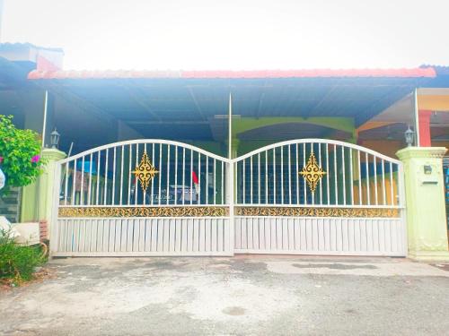um portão branco em frente a uma casa em D'Hiquapis Homestay em Seri Manjung