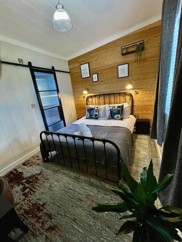 a bedroom with a large bed with wooden walls at Belle Aire Holiday Park in Hemsby