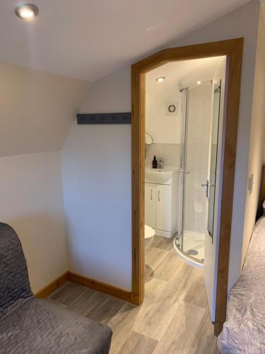 a bedroom with a shower and a glass door at Morvan Pod & Hot tub in Fort William
