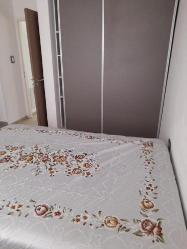 a bed with a white bedspread with flowers on it at España 132 in Villa Regina