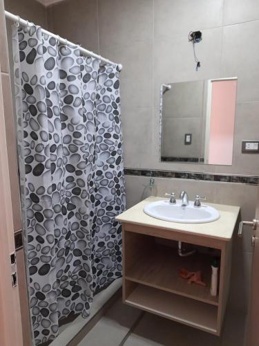 a bathroom with a shower curtain and a sink at España 132 in Villa Regina