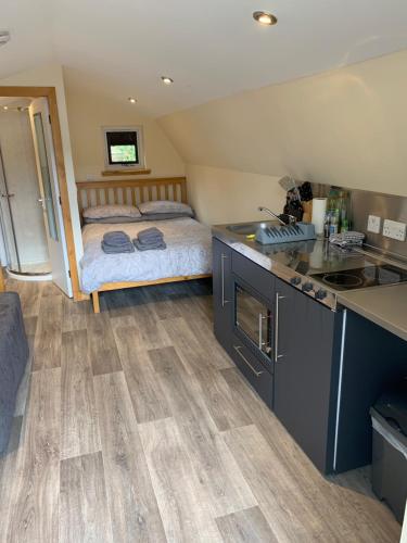 een kamer met een keuken en een slaapkamer met een bed bij Morvan Pod & Hot tub in Fort William