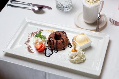 a white plate with a chocolate dessert and a cup of coffee at Restaurant Gästehaus Wiesenheim in Uderns