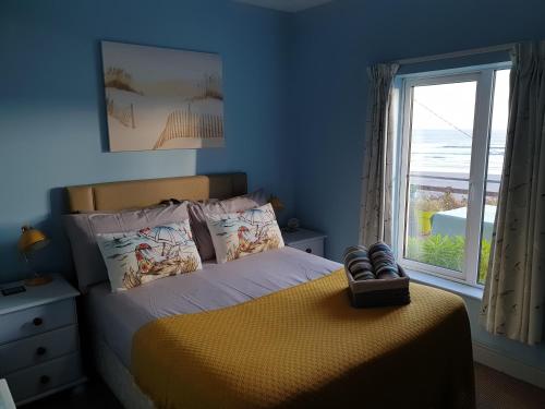 a bedroom with a bed with a large window at Idyllic Inchydoney Beach Cottage - Amazing sea views, path to beach! in Cork