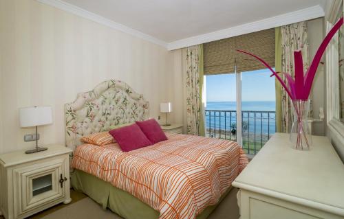 1 dormitorio con 1 cama y balcón con vistas al océano en HB Comfortable Beachfront Holiday Apartment, en Estepona