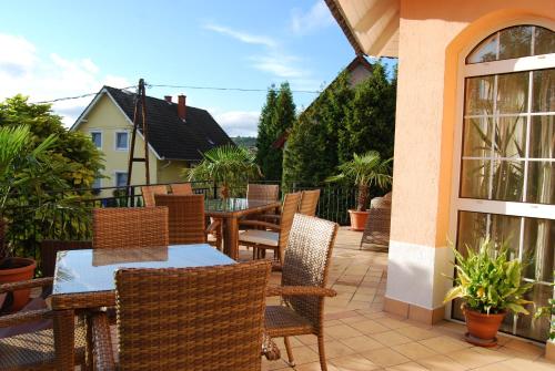 a patio with tables and chairs on a balcony at Barackvirág Vendégház in Tihany