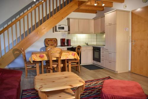 cocina con mesa y sillas en una habitación en Ferienhaus Nr 7B2, Feriendorf Hagbügerl, Bayr Wald en Waldmünchen