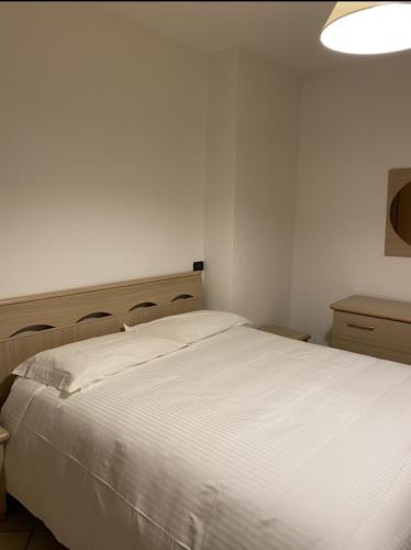 a bedroom with a large white bed with a light above it at Silio 12 in Foligno