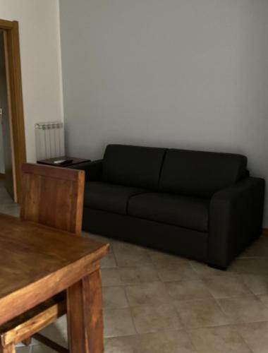 a black couch in a living room with a table at Silio 12 in Foligno