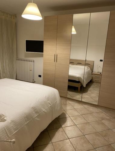 a bedroom with two beds and a mirror at Silio 12 in Foligno