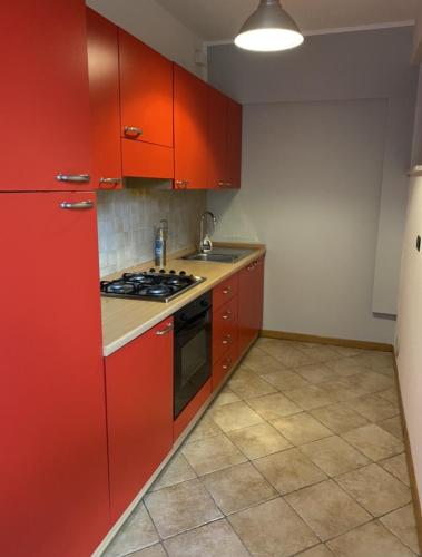 a kitchen with red cabinets and a stove top oven at Silio 12 in Foligno