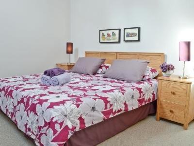 a bedroom with a bed with a red and white comforter at BREATHTAKING VIEWS with a HOT TUB - Bwlch Cliced in Talybont