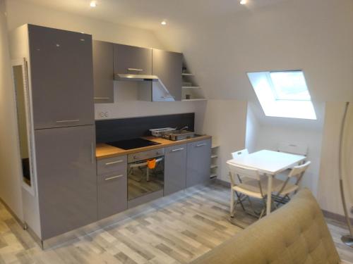 a small kitchen with a table and a counter top at Appartement cosy + accès jardin et salle de muscu in Mardié