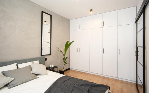 sypialnia z białymi szafkami i dużym łóżkiem w obiekcie Apartament Nakielska 46a lux 40m2 w Bydgoszczy
