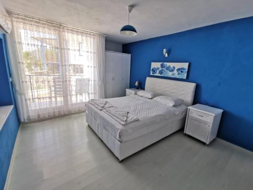 niebieska sypialnia z łóżkiem i niebieską ścianą w obiekcie Mavi Akvaryum Pension w mieście Sogut