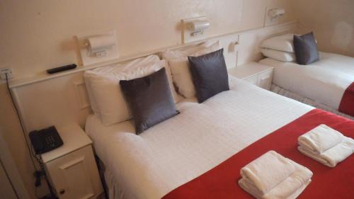 um quarto com 2 camas num pequeno quarto em Arran House Hotel em Londres