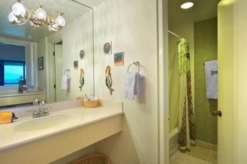 La salle de bains est pourvue d'un lavabo, d'un miroir et d'une douche. dans l'établissement Hanalei Bay Resort 7302, à Princeville