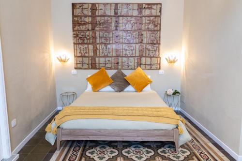 a bedroom with a large bed with yellow pillows at TRESCA CHARME luxury Rooms in Bari