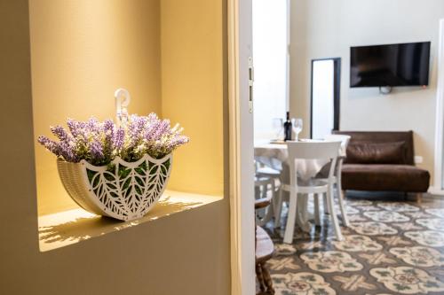 un jarrón de flores púrpuras sentado en un mostrador en una habitación en TRESCA CHARME luxury Rooms, en Bari