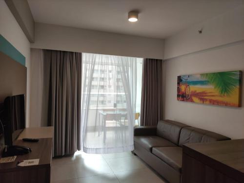 un salon avec un canapé et une grande fenêtre dans l'établissement Apartamento em Olímpia, à Olímpia