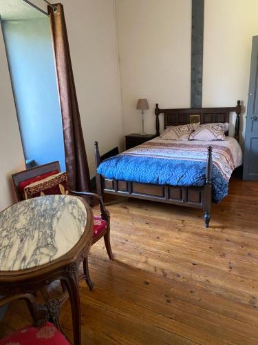 a bedroom with a bed and a table and chairs at Tour du Château de Gondole in Le Cendre