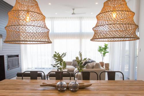 two chandeliers above a wooden table in a living room at Lefties @ The Bay, Gracetown, Margaret River - NEW in Gracetown