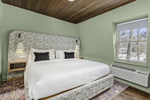 a bedroom with a large bed and a window at The Neighborhood Hotel Grand Beach in New Buffalo