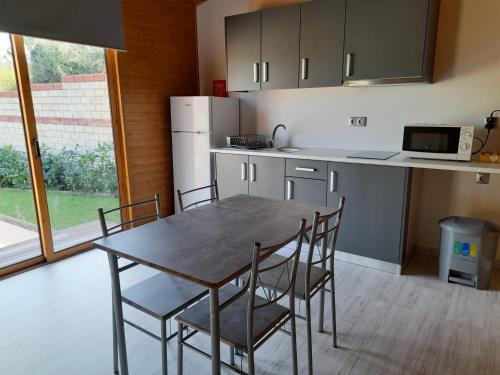 uma cozinha com uma mesa e cadeiras e um frigorífico em Leiria Village casa bungalow em Leiria