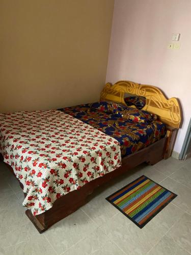 a bedroom with a bed with a quilt on it at Appartement et Chambres in Bamako