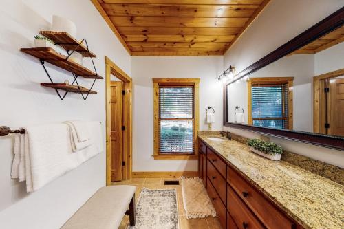 ein Badezimmer mit Waschbecken und Spiegel in der Unterkunft Le Hermitage in Ellijay