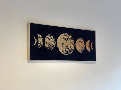 a framed picture of phases of the moon at Hatfield Haven - Modern 2-Bed Retreat near Uni, Business Park & City Center, FREE Parking, Big savings on Longer Stays in Hatfield