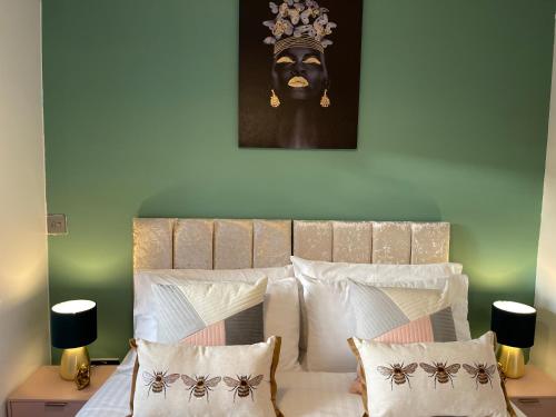 a bedroom with a bed with a headboard and a painting at Hatfield Haven - Modern 2-Bed Retreat near Uni, Business Park & City Center, FREE Parking, Big savings on Longer Stays in Hatfield