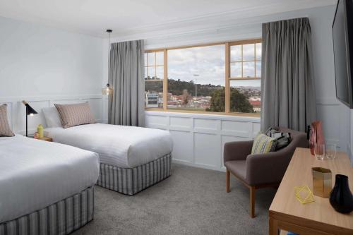 ホバートにあるリッジス ホーバートのベッド2台と窓が備わるホテルルームです。