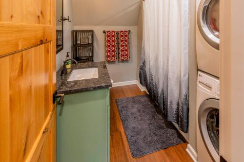 uma casa de banho com um lavatório e uma máquina de lavar roupa em A-Frame of Mind em Rhododendron
