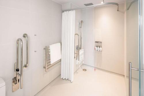 a hospital room with white walls and a walk in shower at YOTEL London City in London