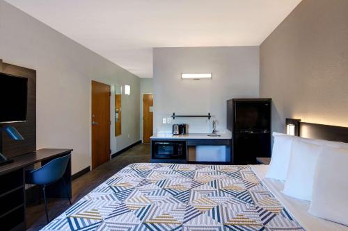 a hotel room with a large bed and a kitchen at Studio 6 Pensacola, FL - West I-10 in Pensacola