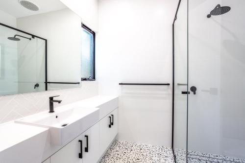 a white bathroom with a sink and a shower at Rambles Landing - get lost amongst the trees - NEW in Margaret River Town