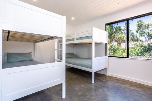 two bunk beds in a room with a window at Rambles Landing - get lost amongst the trees - NEW in Margaret River Town