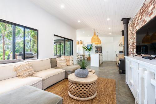 a living room with a couch and a table at Rambles Landing - get lost amongst the trees - NEW in Margaret River Town