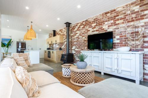 a living room with a brick wall at Rambles Landing - get lost amongst the trees - NEW in Margaret River Town