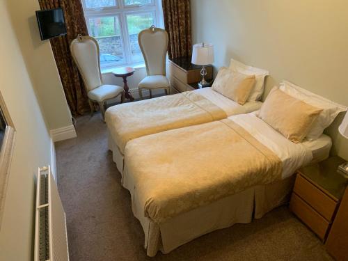 a bedroom with a bed and two chairs and a window at Entire Seaside Home, Sleeps 8, All en-suite rooms in New Brighton