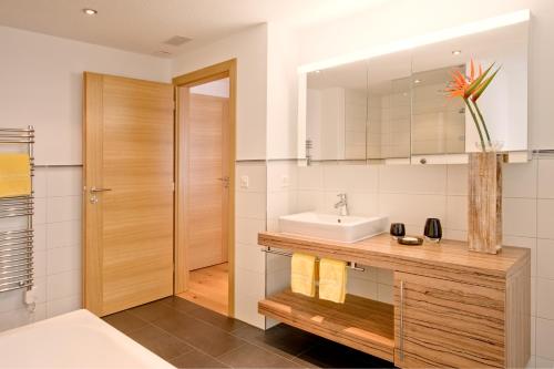y baño con lavabo y espejo. en Jägerhof Serviced Apartements, en Zermatt